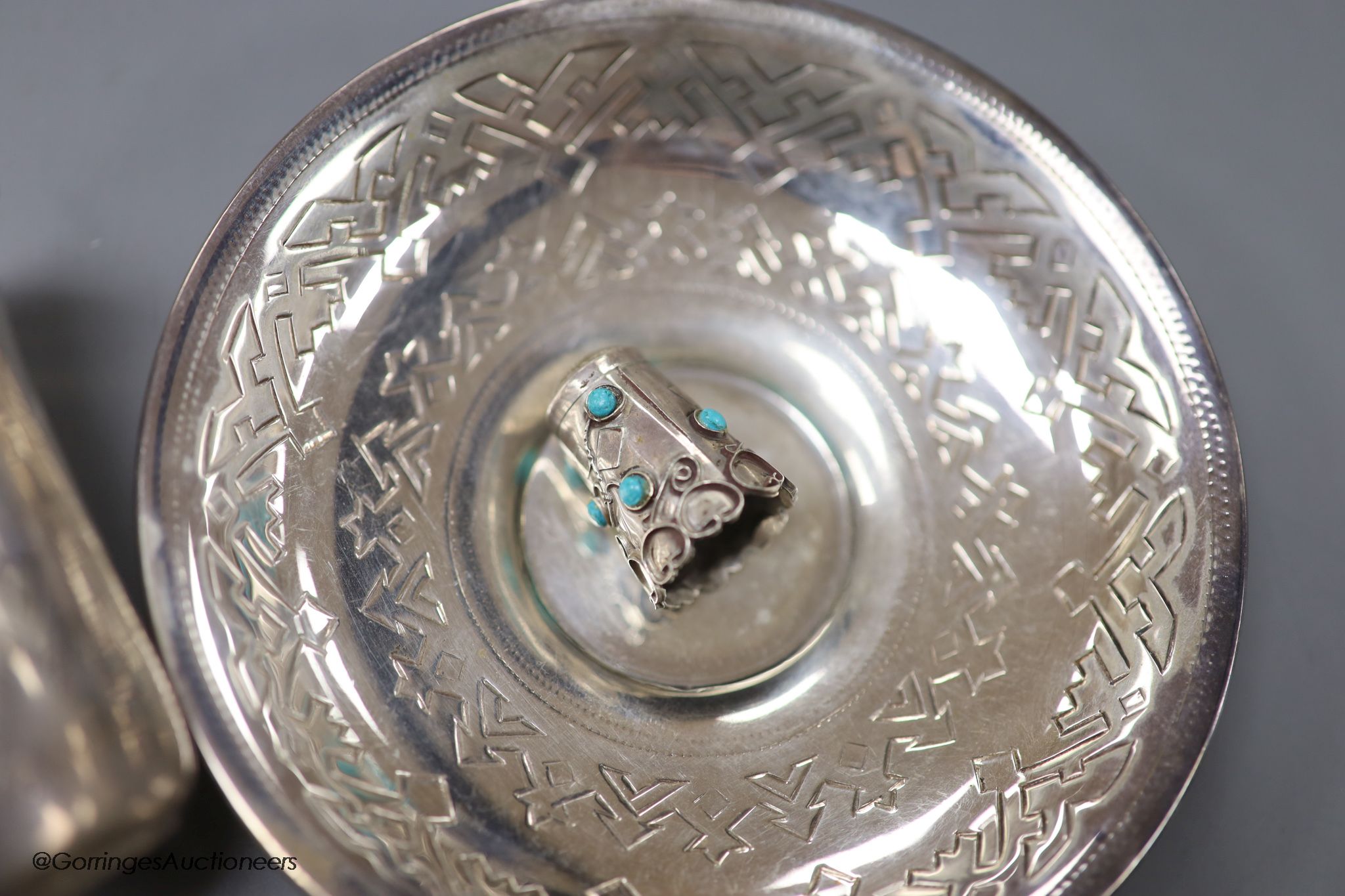 A late 19th century Russian engraved 84 zolotnik beaker, 1893, 63mm, a similar saucer, 1886, three assorted similar spoons, a white metal thimble and pendant and a German 835 tea strainer